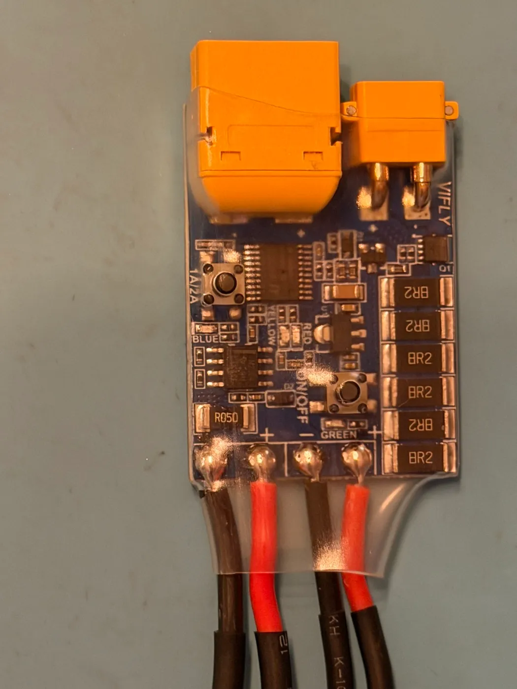 The ShortSaver V2 smoke stopper from this build: an XT60 on each end of a small PCB with a 1A/2A current-limit button and an ON/OFF button