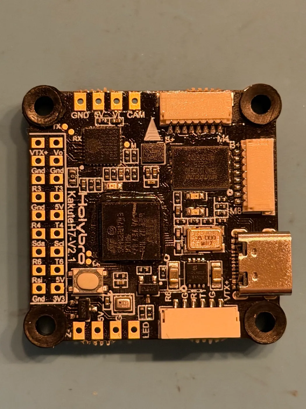 The actual Kakute H7 V2 from this build, top-down: the paired solder-pad column on the left edge reads VTX+/Vo, Gnd/Gnd, R3/T3, Gnd/5V, R4/T4, Sda/Scl, R6/T6, Rsi/5V, Gnd/3V3