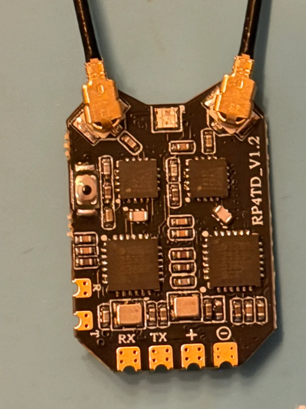 The RP4TD receiver from this build, bottom side: four solder pads along the edge labeled RX, TX, plus and minus, with two IPEX antenna connectors at the top